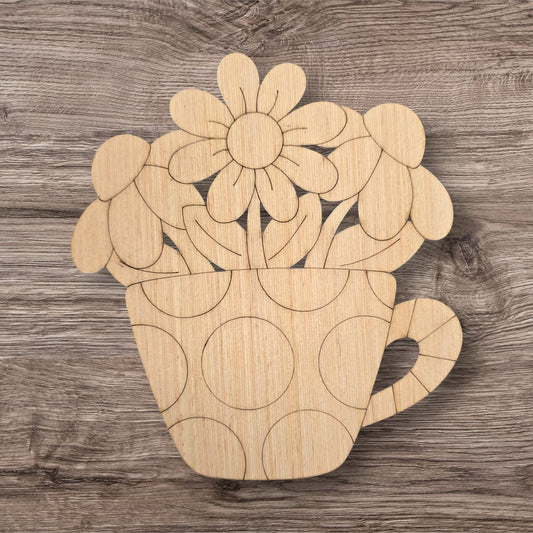 Wooden cutout of a teacup with flowers on a wooden surface