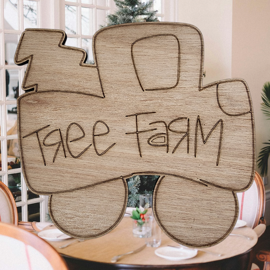Unfinished wood cutout of a vintage truck with a Christmas tree, engraved with the words "Tree Farm".