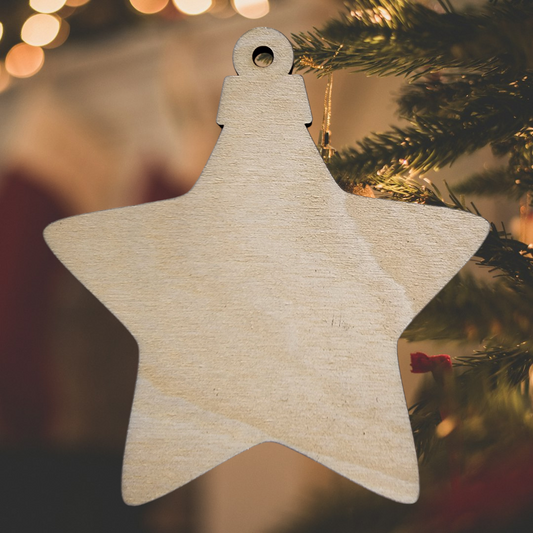 Unfinished wooden star ornament blank hanging on a Christmas tree.
