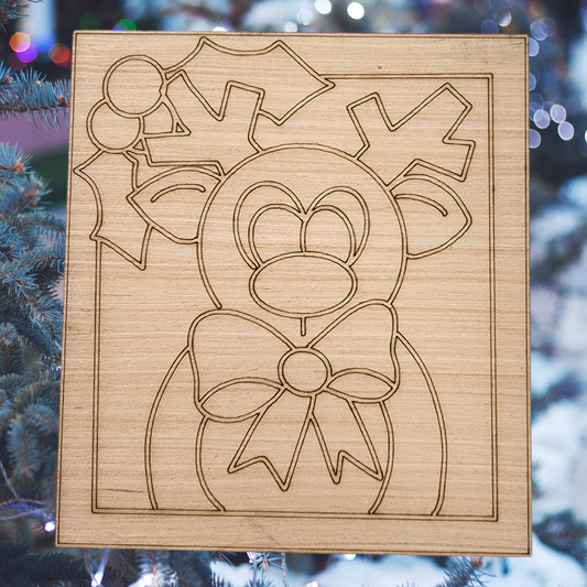 Unfinished square wood blank with an engraved design of a cute reindeer with a bow tie and holly.