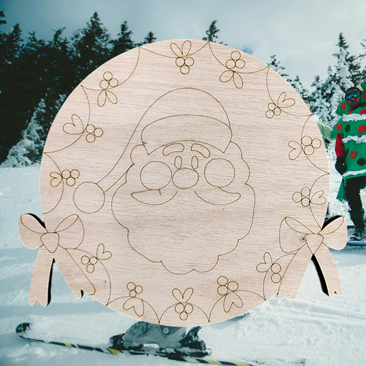 Unfinished round wood sign engraved with a Santa face inside a holly wreath.